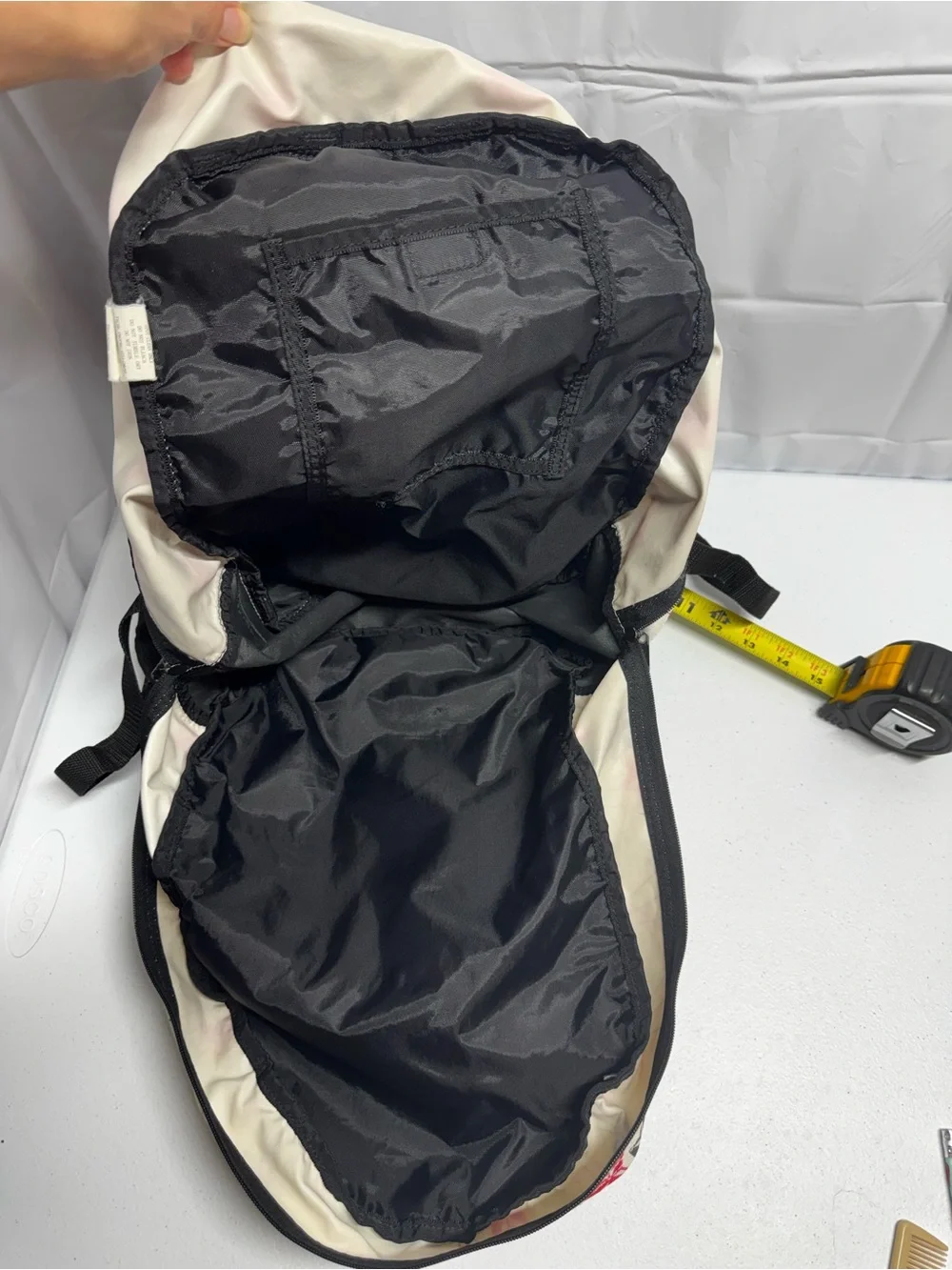 Fox Racing white polyester backpack with red, blue, and black stars and lines